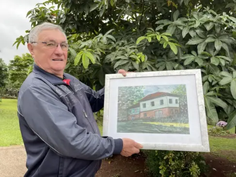 Celso Lírio Piccinini mora há mais de 40 anos em Vila Santa Emília e tem em casa o quadro da residência onde cresceu, em Roca Sales (Foto: Débora Kist/Folha do Mate)