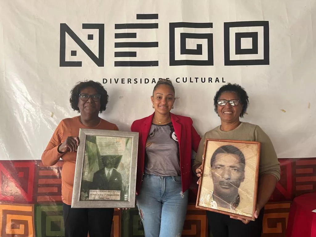 Maria Isabel com a foto do pai, João Generoso dos Santos, o fundador e primeiro presidente do Négo; Jaqueline e Maria Elisete com a foto de Leobaldo Rodrigues, conhecido por Tio Béco, um dos presidentes mais populares do Négo, o criador da expressão ‘Rua Grande’ para a Osvaldo Aranha, principal rua de Venâncio, onde são realizados os desfiles de Carnaval. (Foto: Luana Schweikart)