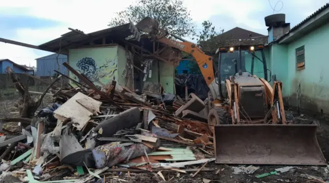 Retroescavadeira colocou abaixo a casa que era usada como reciclagem (Foto: Alvaro Pegoraro)