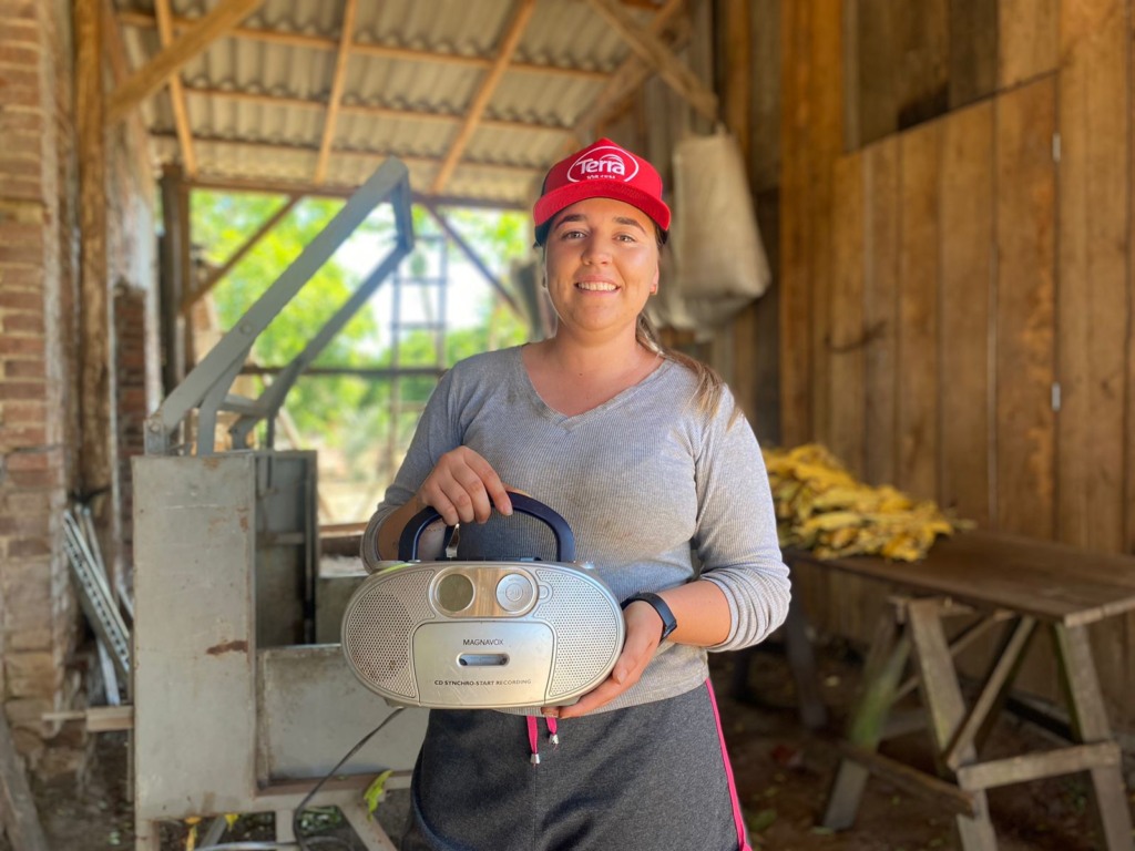 O rádio da falecida avó Ercília é o companheiro diário de Thamires na lida do tabaco. (Foto: Júlia Brandenburg/Folha do Mate)