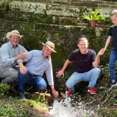 Profissionais da CTA (à esquerda), Junior e seu filho mostram a boa vazão que tem o reservatório (Foto: Juan Grings)