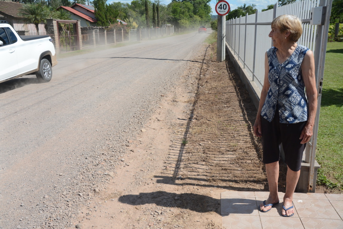 Sem o asfalto, a aposentada Gisela Schuster sofre diariamente com a poeira (Foto: Alvaro Pegoraro/Folha do Mate) Sem o asfalto, a aposentada Gisela Schuster sofre diariamente com a poeira (Foto: Alvaro Pegoraro/Folha do Mate)
